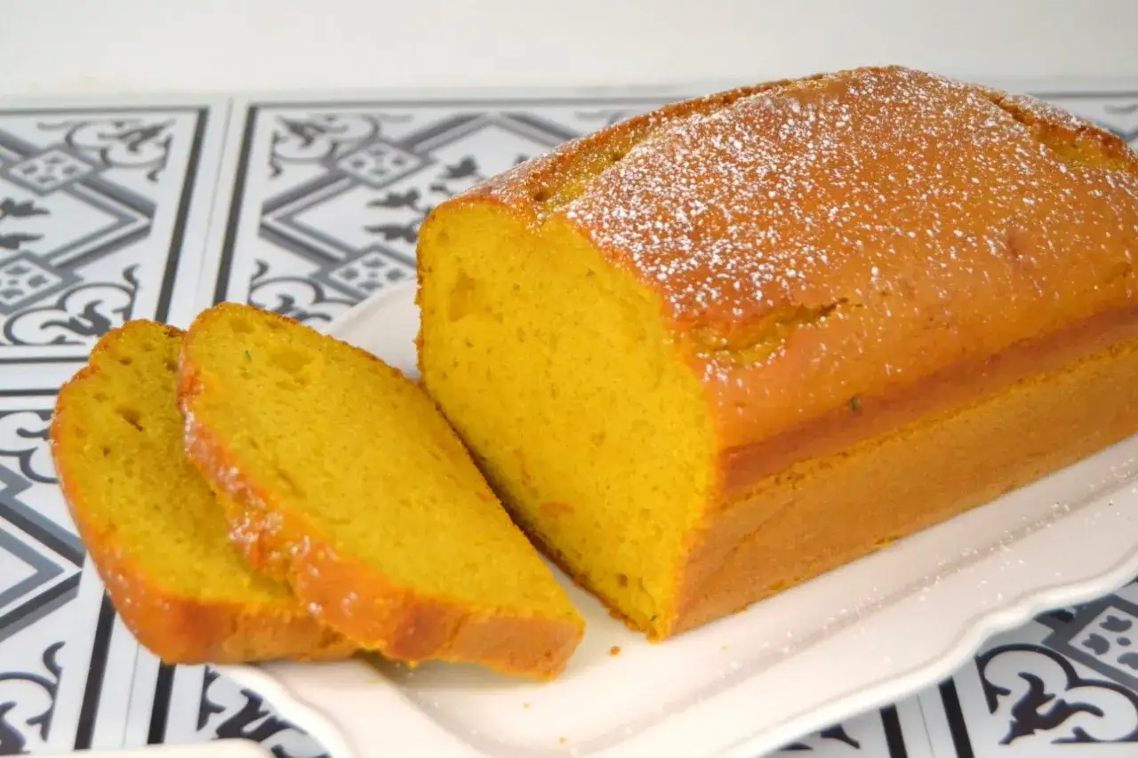Bizcocho de calabaza esponjoso y dorado, espolvoreado con az&uacute;car glas. Dos rebanadas cortadas muestran su interior h&uacute;medo y vibrante.