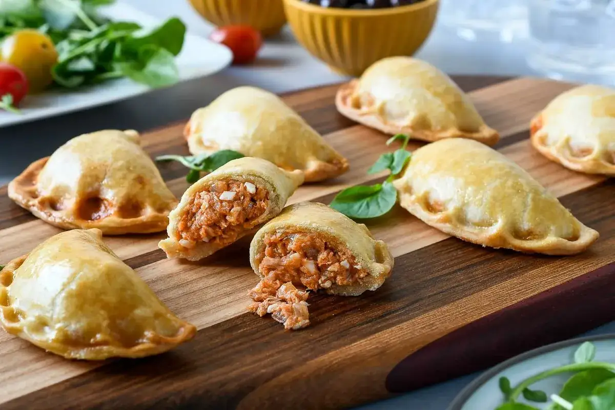 Empanadillas doradas rellenas de salmón, perfectas para tus recetas con obleas de empanadillas. Un bocado delicioso.