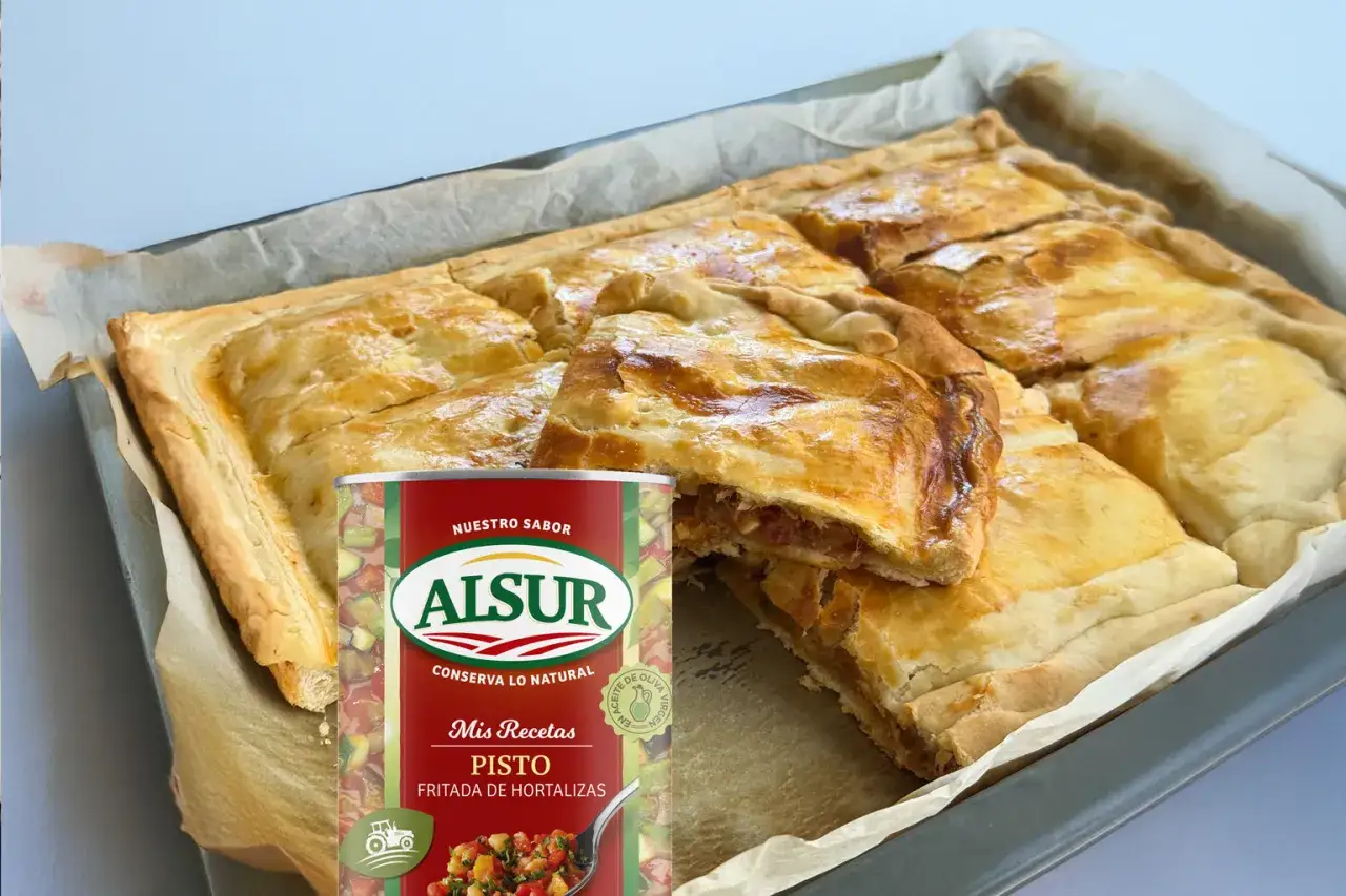 Empanada de pisto casera, dorada y crujiente, lista para disfrutar. Acompañada de una lata de pisto de Alsur, para un sabor auténtico.