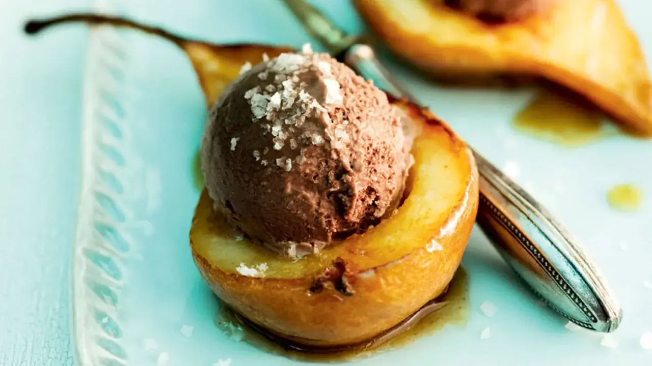 Peras asadas con una bola de helado de chocolate y sal marina, un postre delicioso.