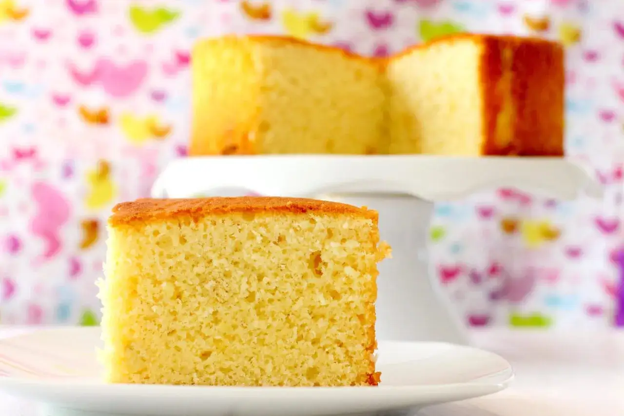 Un trozo de bizcocho de yogur, esponjoso y dorado, listo para disfrutar. La receta de la abuela nunca falla.