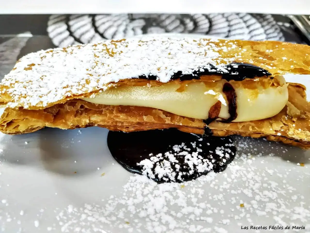 Delicioso milhojas de chocolate con crema y espolvoreado de azúcar glas.