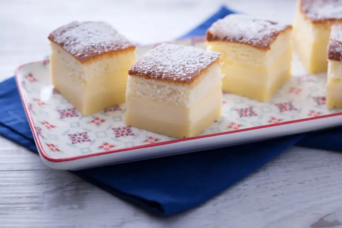 Pastel m&aacute;gico de capas esponjosas y crema suave, espolvoreado con az&uacute;car glas.