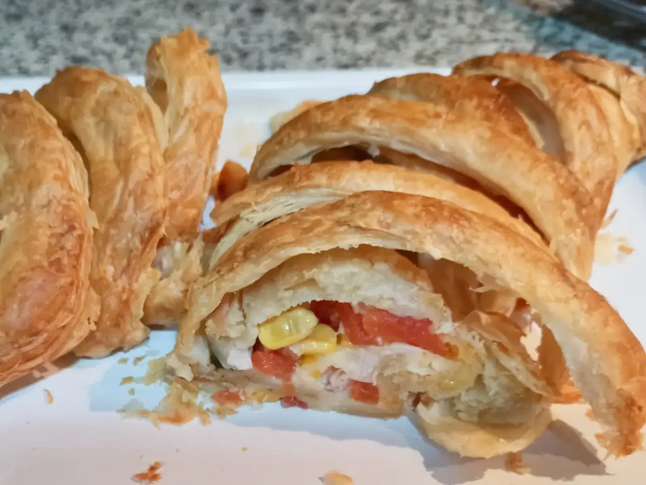 Deliciosa receta con hojaldre salado, relleno de pollo, tomate y ma&iacute;z. Un bocado crujiente y sabroso.