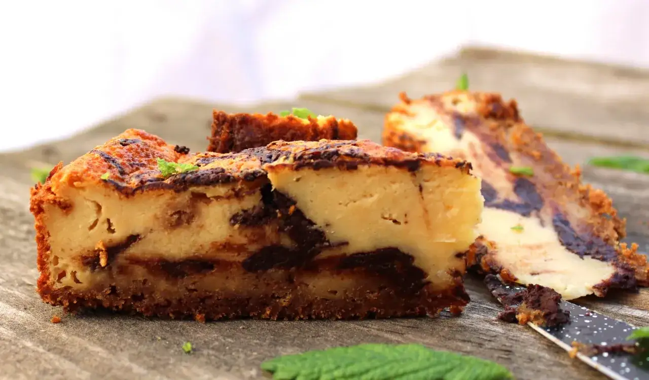 Deliciosa tarta de queso con chocolate, con trozos de chocolate oscuro integrados en la cremosa masa y una base crujiente.