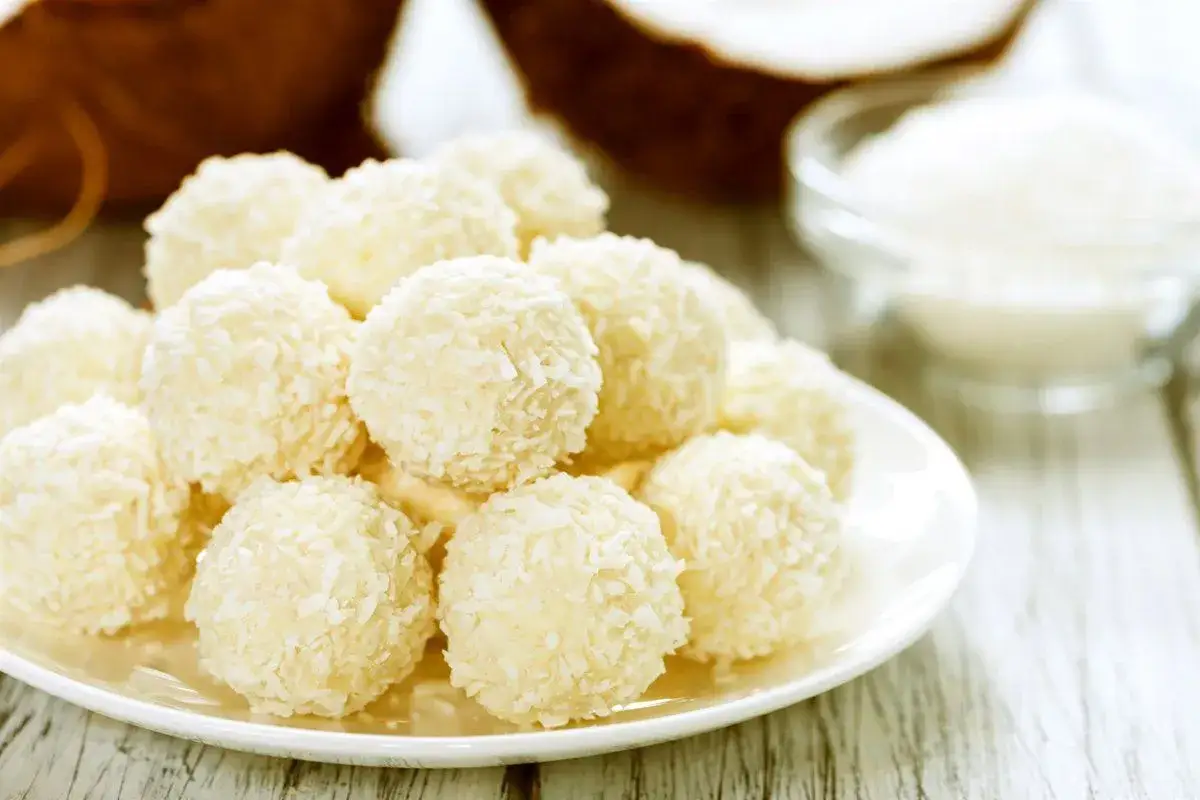 Deliciosas trufas de coco cubiertas con coco rallado, listas para disfrutar.