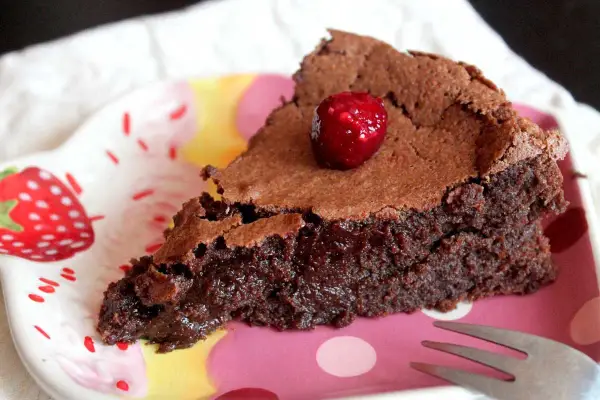 Deliciosa tarta sin gluten y sin lactosa, con un centro fundente y coronada con una frambuesa.